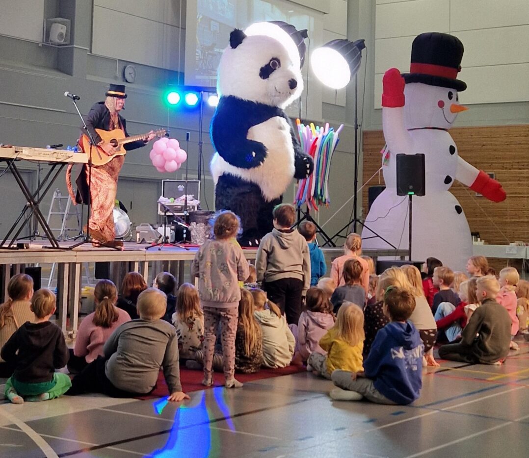 Lapsia lattialla kuuntelemassa esiintyjää