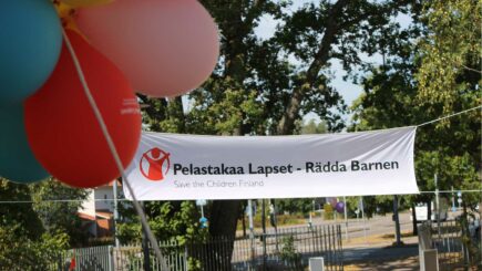 Pelastakaa Lasten banneri ja ilmapalloja ulkona.