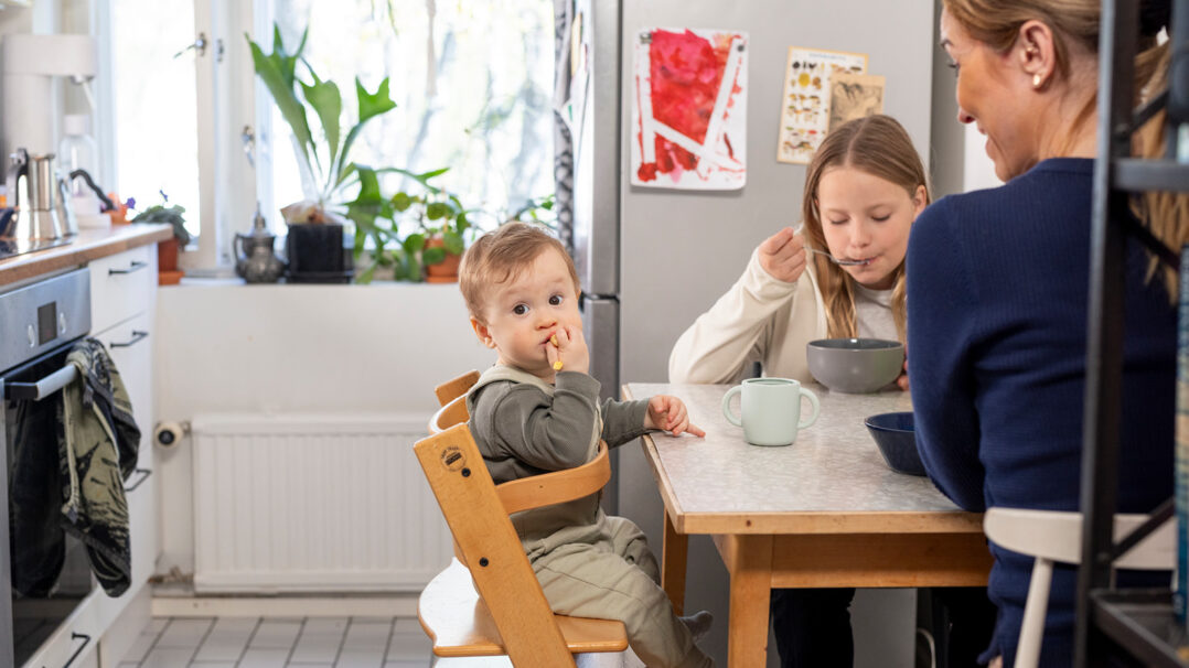 Perhe syö pöydän ääressä keittiössä