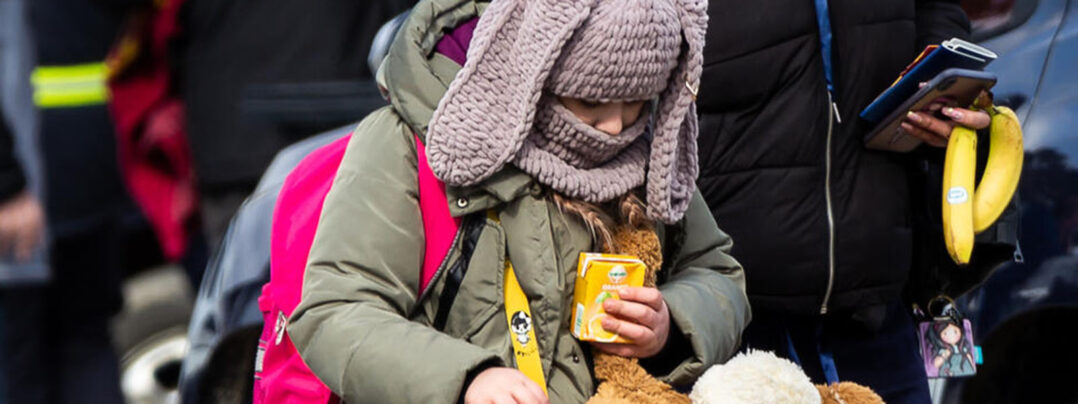 Kuvassa Ukrainan sotaa paennut lapsi kantaa reppua ja pehmolelua.