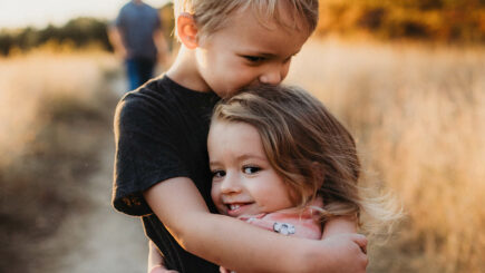 Poika ja tyttö halaavat toisiaan.