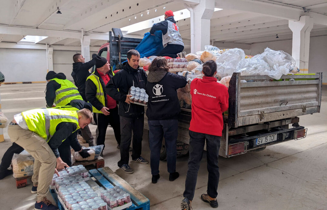 Kuvassa Pelastakaa Lasten työntekijät pakkaavat Ukrainaan lähetettävää ruoka-apua autoon Romaniassa.