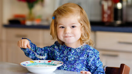 Pieni tyttö syö keittoa.