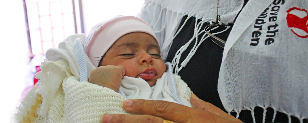 Kuvassa jemeniläinen vauva Pelastakaa Lasten työntekijän sylissä