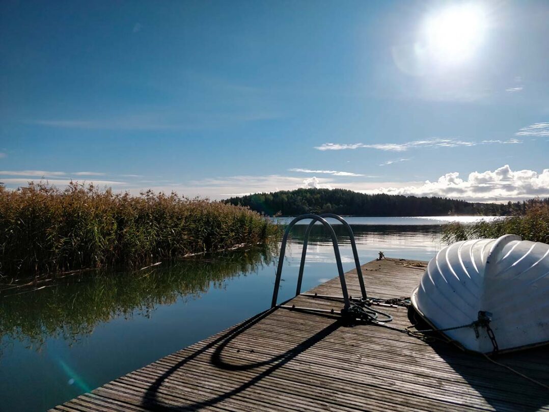 lastenkoti suvilinnan pihalla vene laiturilla aurinkoisena kesäpäivänä