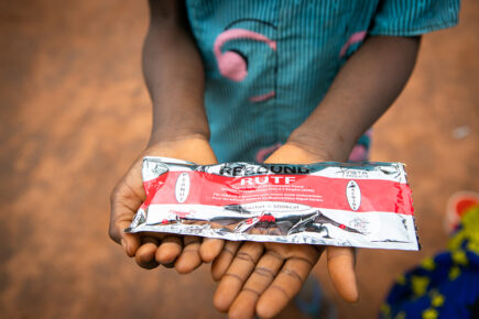 Paketti ravitsevaa maapähkinätahnaa lapsen kädessä