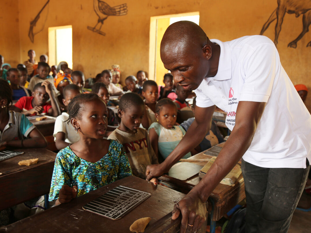 Pelastakaa Lapset työntekijä opettaa lapsia koululuokassa Malissa.