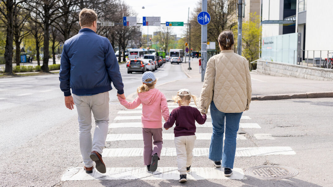 Kaksi aikuista ja kaksi lasta ylittävät suojatien
