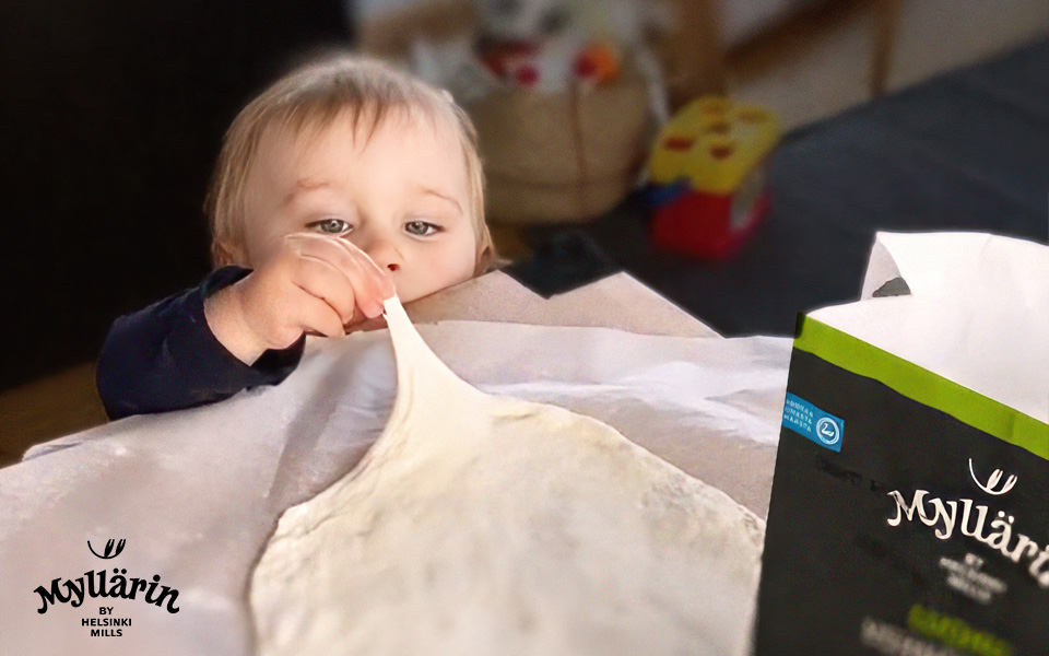 Lapsi nappaa taikinaa pöydältä.