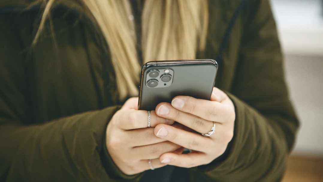 Nuori pitää kännykkää kädessään