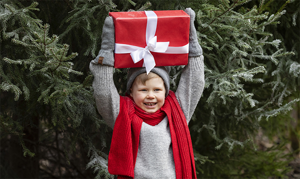 Poika pitelee käsissään lahjapakettia.