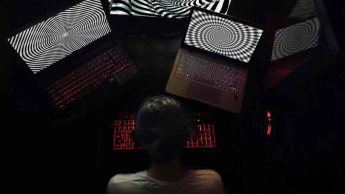 Nuori tietokoneen ruutujen äärellä.