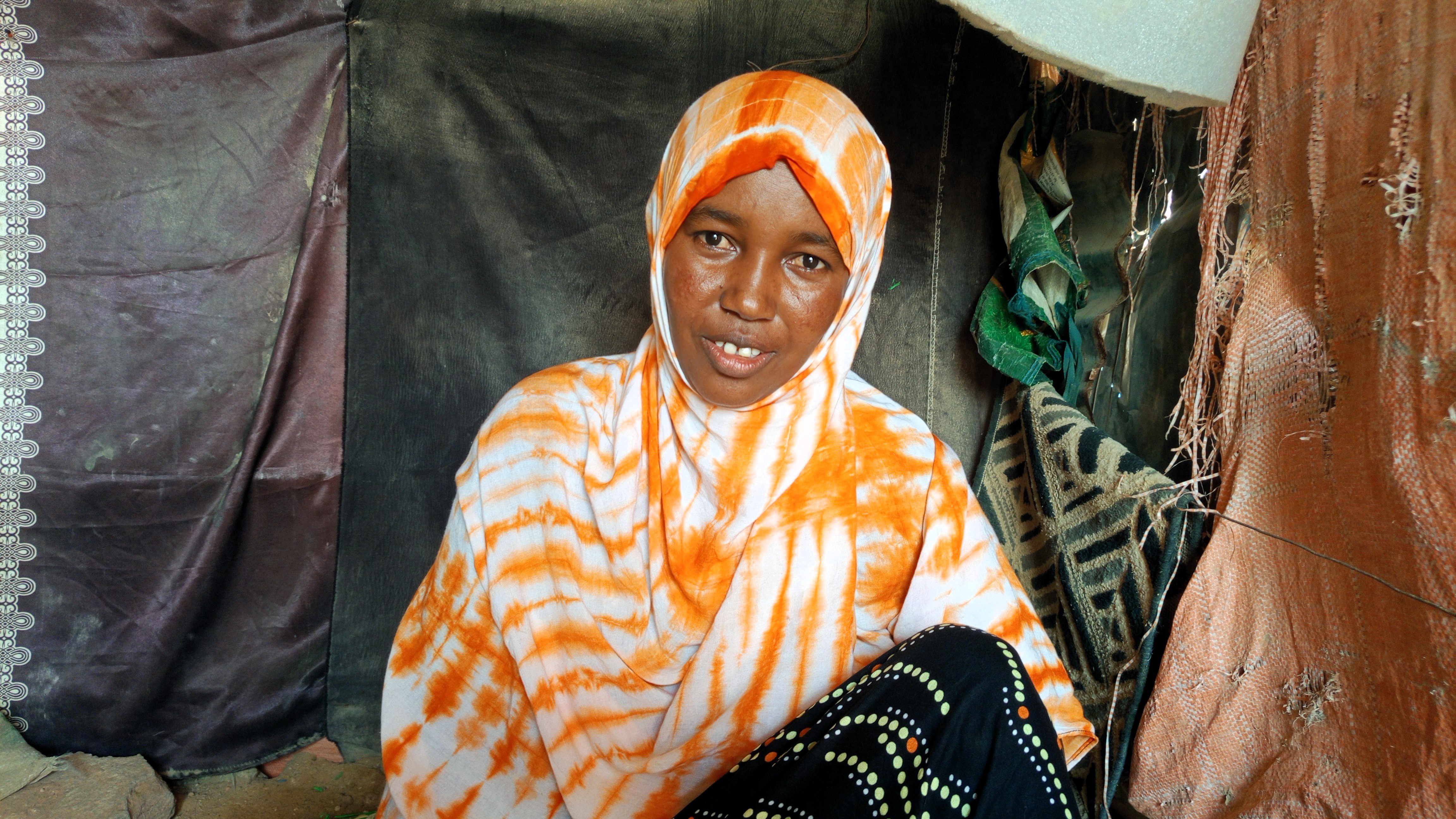 Nainen istuu teltassa.