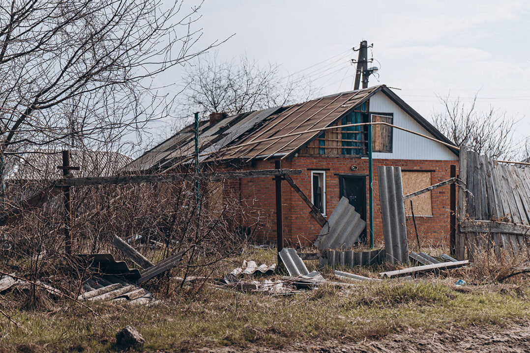 Vaurioitunut talo, jonka edessä on kaatunut aita.