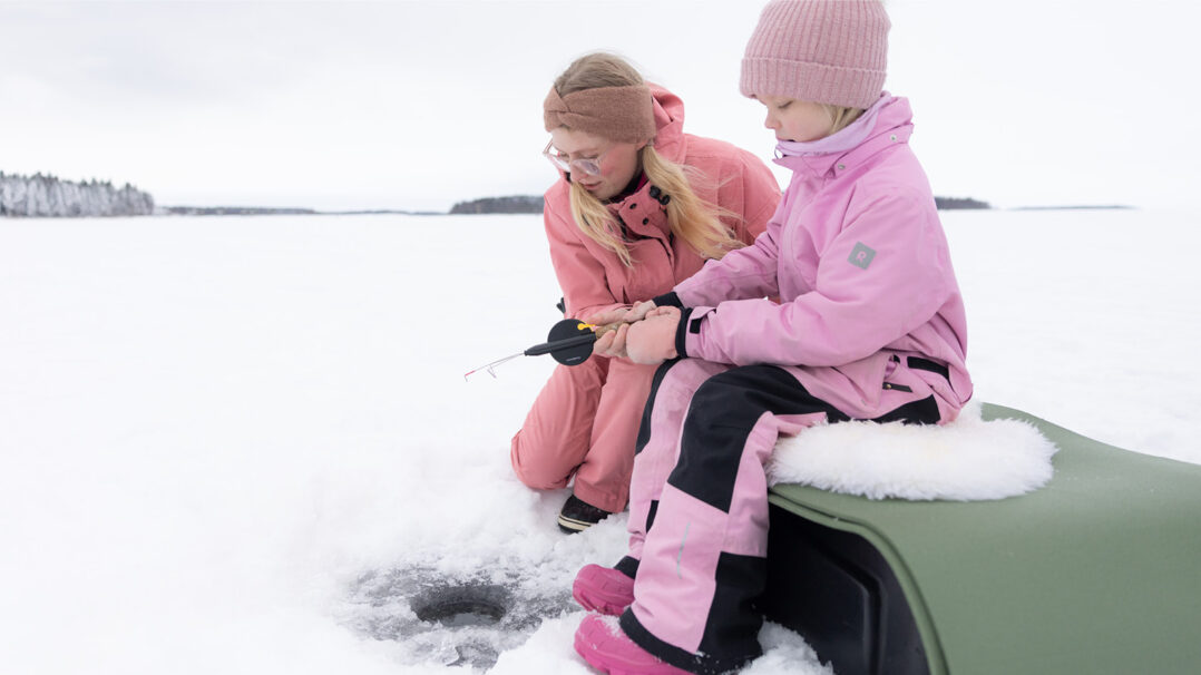 Tyttö ja nainen jään päällä pilkkimässä